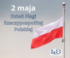 Flaga Polski na maszcie na tle pochmurnego nieba. Obok widnieje napis: ‘2 maja – Dzień Flagi Rzeczypospolitej Polskiej’. W prawym dolnym rogu znajduje się logo Kuratorium Oświaty we Wrocławiu.